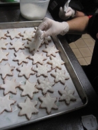 Piping icing on snowflake cookies